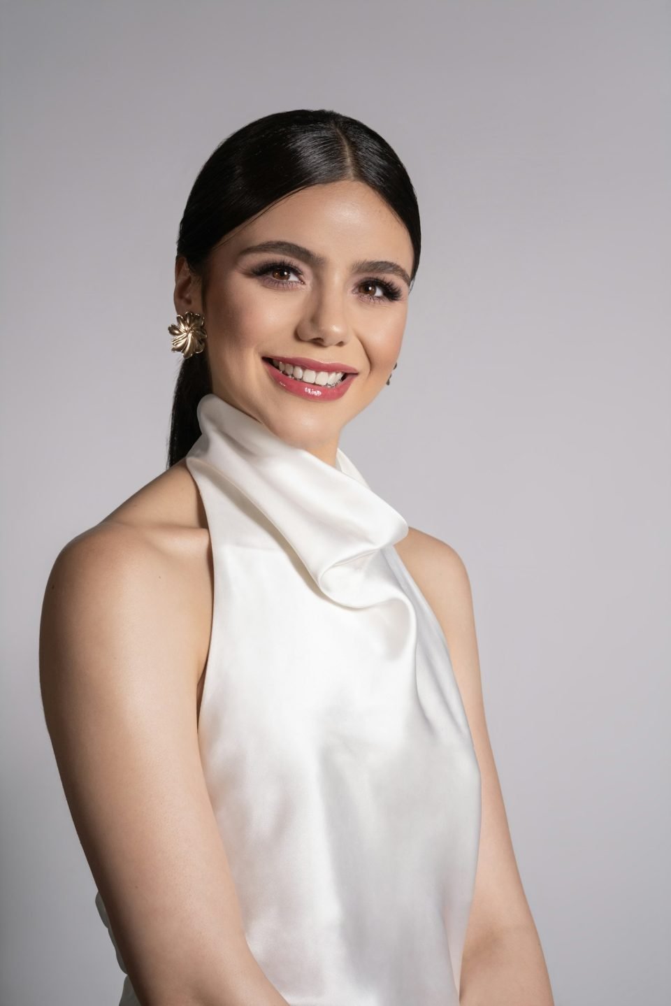 Maria in an ivory silk top, smiling softly